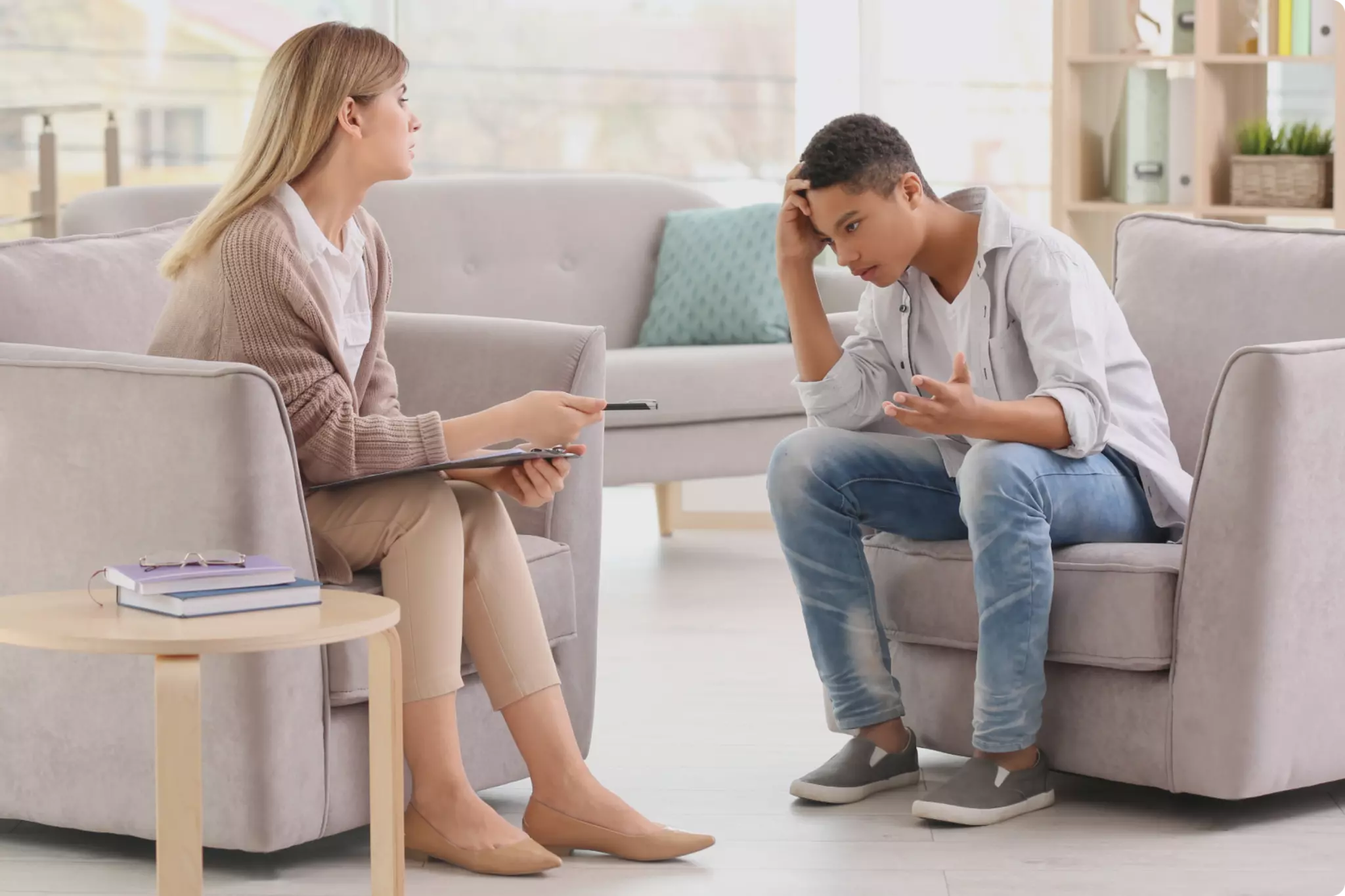 Une psychiatre qui écoute un jeune homme en détresse dans son cabinet